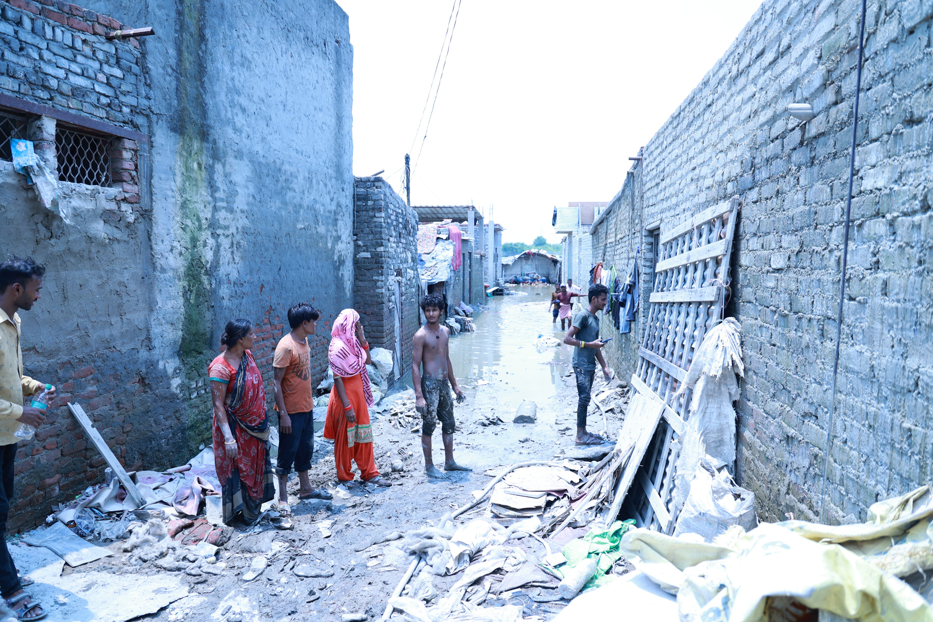 Människor som står på gatan i ett katastrofdrabbat område i norra Indien.
