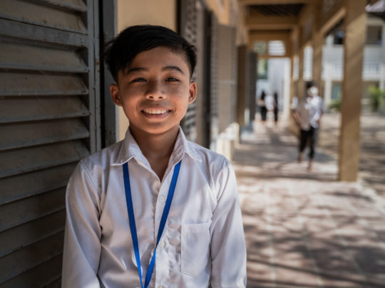 Sereyvat står framför en vägg. Han bär en skjorta och ler mot kameran.