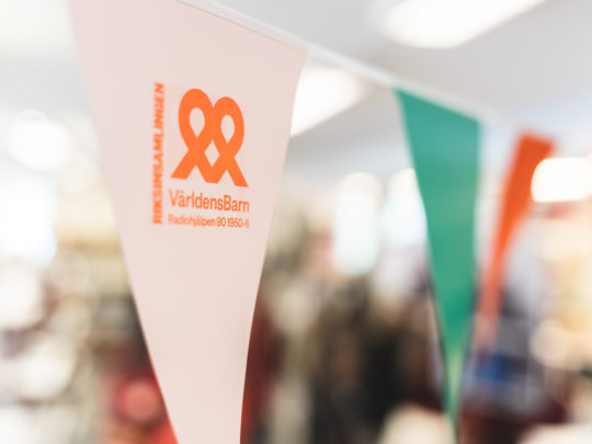 Vimplar med Världens barn logotyp på. 