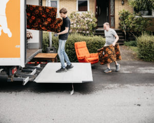 Människor bär in möbler in i lastbil från Erikshjälpen Second Hand.