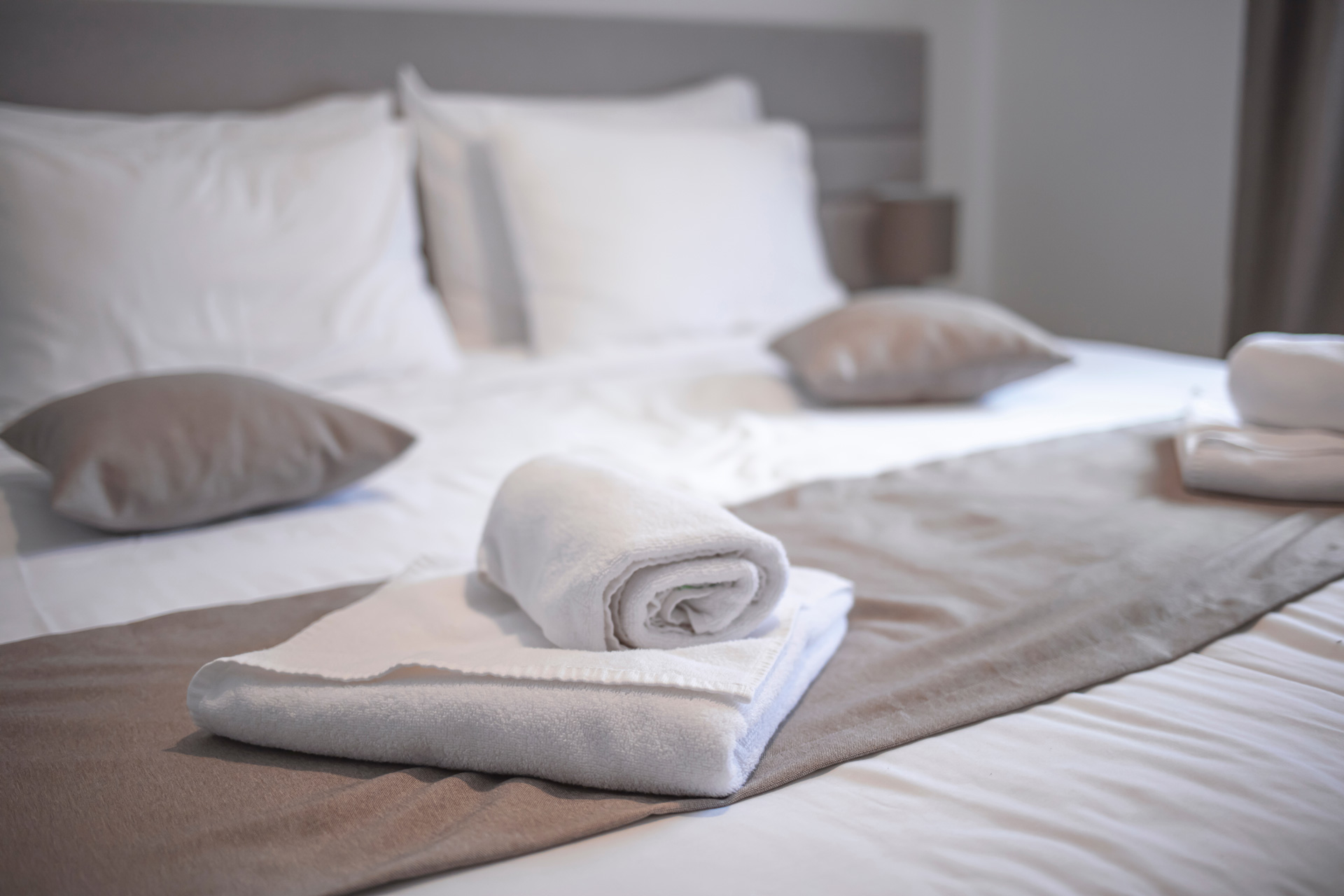 En hotellsäng med vita handdukar på.