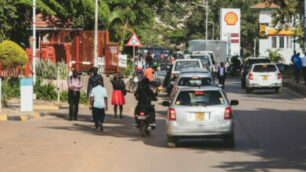 Människor och bilar på en trafikerad väg i Uganda.