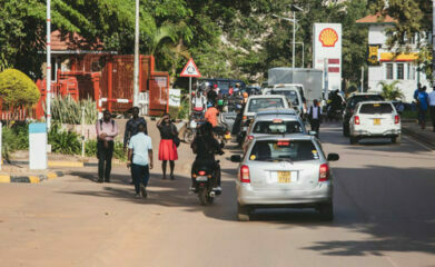 Människor och bilar på en trafikerad väg i Uganda.