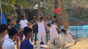 Barn leker på baksidan av ett barncenter i Bangladesh.