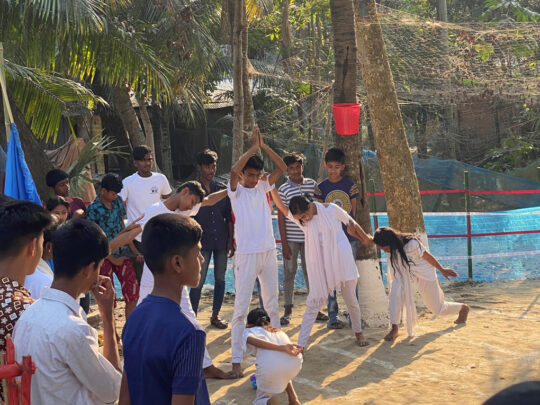 Barn leker på baksidan av ett barncenter i Bangladesh.
