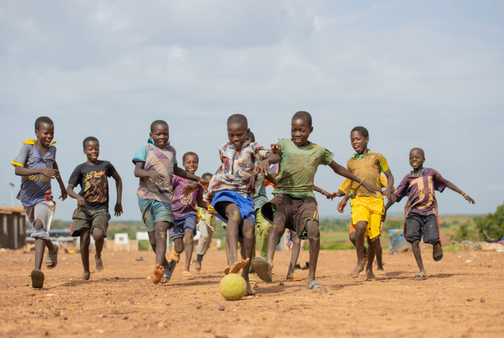 Pojkar spelar fotboll barfota i Burkina Faso.