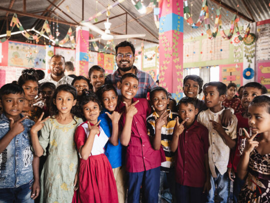 En skolklass tillsammans med sin lärare i Bangladesh.