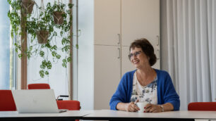 Gudrun Brunegård sitter vid ett konferensbord i Erikshjälpens lokaler.