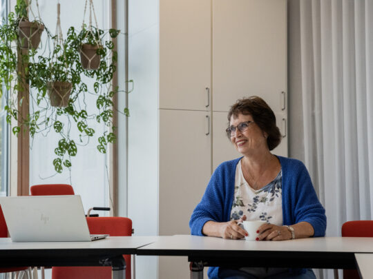 Gudrun Brunegård sitter vid ett konferensbord i Erikshjälpens lokaler.