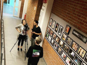 Elever i en skola står i en korridor och spelar in film om barnkonventionen.