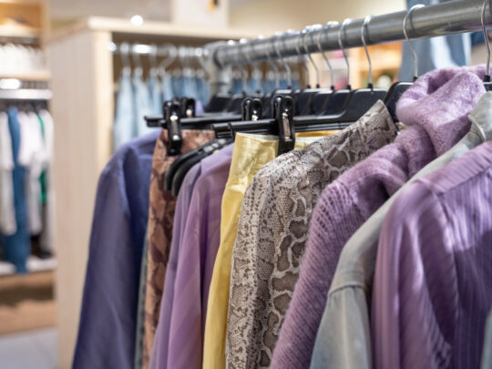 Clothes hanging on a clothes rail in one of Erikshjälpen Second Hand's shops.