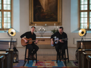 Paul Biktor Börjeson och Erik Tilling med varsin gitarr i en kyrka.