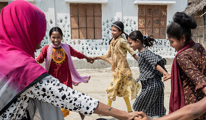 Barn håller varandra i händerna och dansar i en ring.