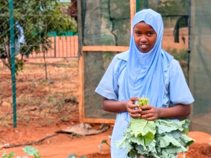 Malich holding cale in her hands in the school garden.