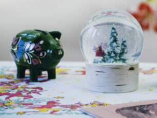 En julig spargris i grönt och en snöglob