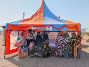 Medlemmar i självhjälpsgruppen i Machi står i ett av gruppens tält.