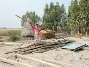 Nedmontering av skola i Bangladesh pågår. På marken ligger balkar och andra delar av skolbyggnaden.