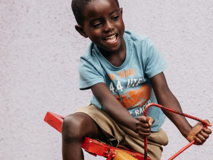 A boy swings happily on a seesaw.