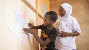 Rishanata hjälper Ali att sätta upp stjärnformade papper på väggen i skolan.