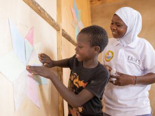 Rishanata hjälper Ali att sätta upp stjärnformade papper på väggen i skolan.