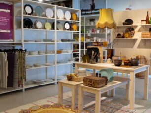 Erikshjälpen Second Hand butik med kläder och köksprylar i bild. 