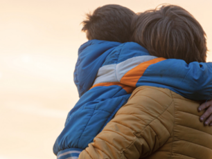 Barn och förälder kramas.