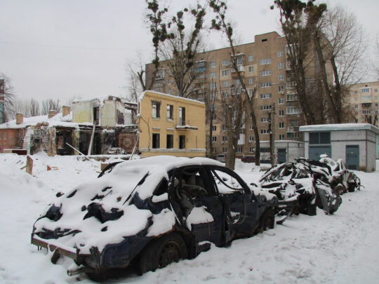Utbrända bilvrak och förstörda hus till följd av en ryska raketattack i en förort till Kiev.
