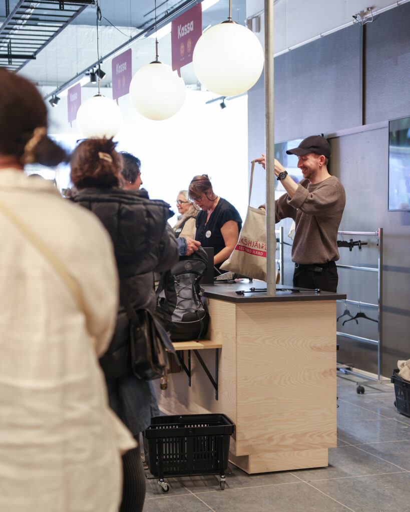 Kunder köar till kassadisken i Erikshjälpens second hand-butik på Backaplan.