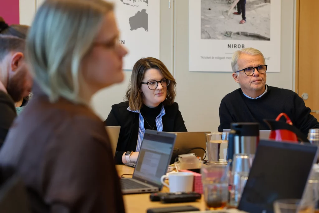 Medarbetare från organisationen Cord sitter i ett mötesrum tillsammans med medarbetare från Erikshjälpen.