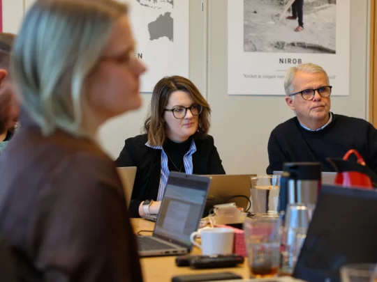 Medarbetare från organisationen Cord sitter i ett mötesrum tillsammans med medarbetare från Erikshjälpen.