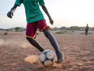 En pojke spelar fotboll