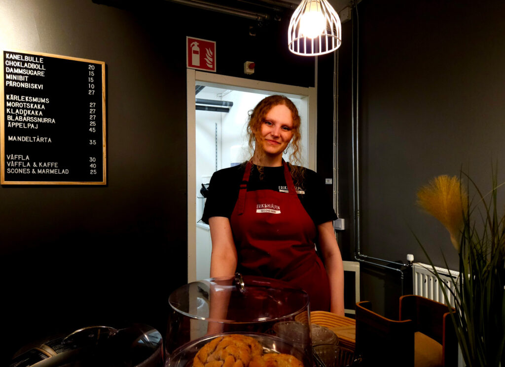 Volontären Linnea står bakom bullar och kakor i Eriks kafé.